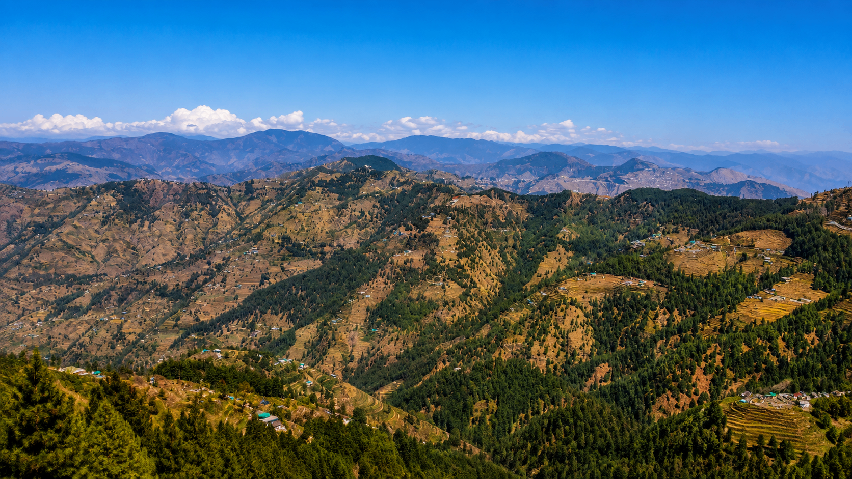 Wide panorama of Himalayan ridges and terraced slopes seen from New Kufri
