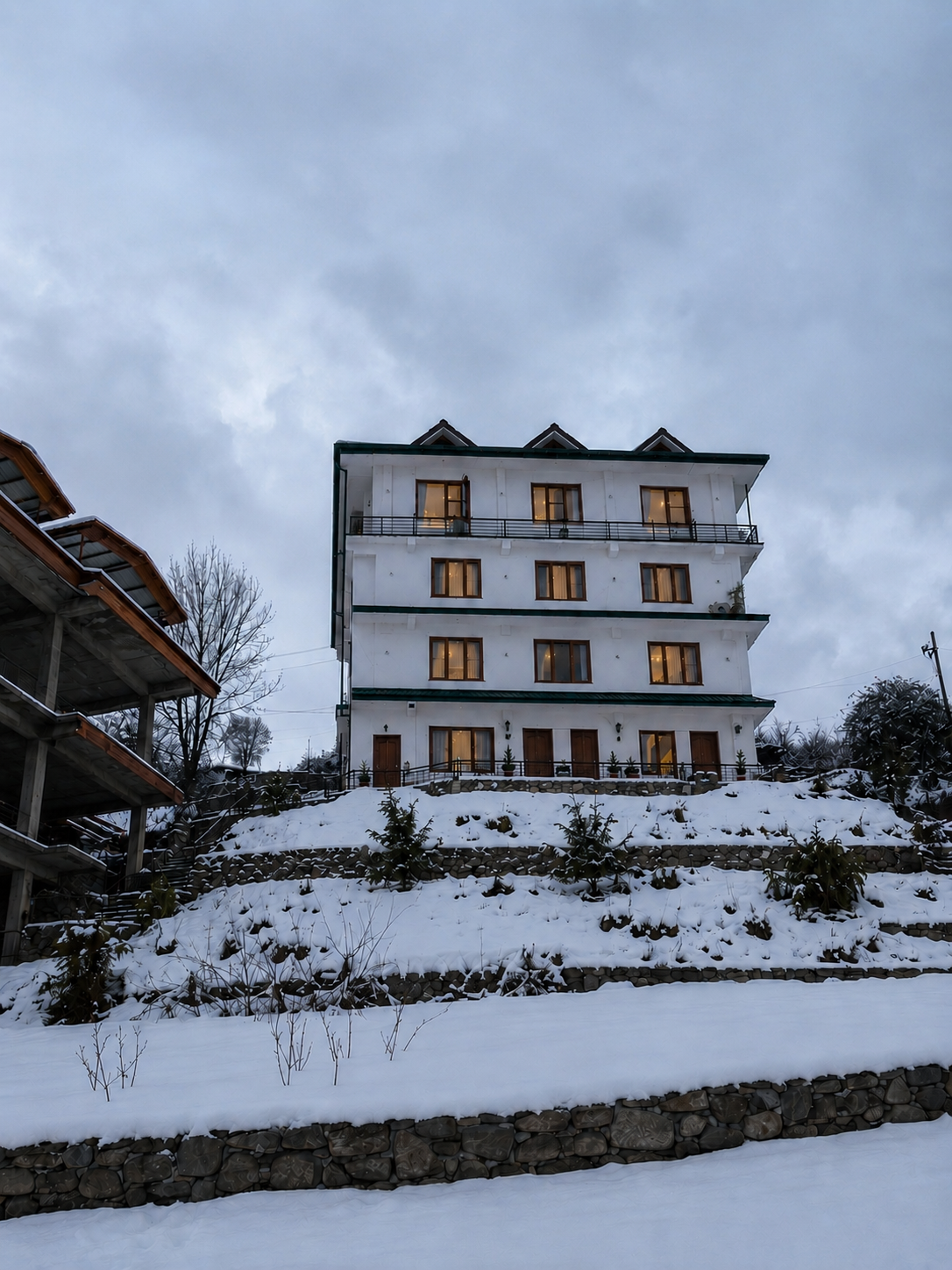 New Kufri Home Stay building lit up on a snow-covered hillside